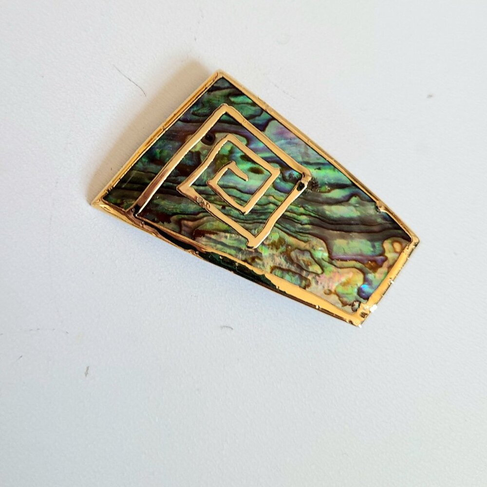 Abalone shell brooch with gold details.